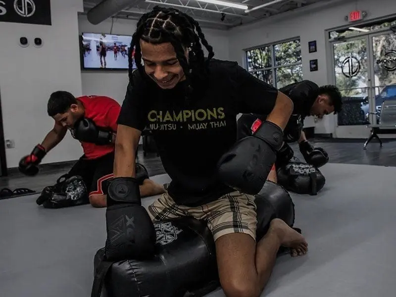 Adult Muay Thai and Jiu Jitsu class practicing ground striking drills in Orlando gym